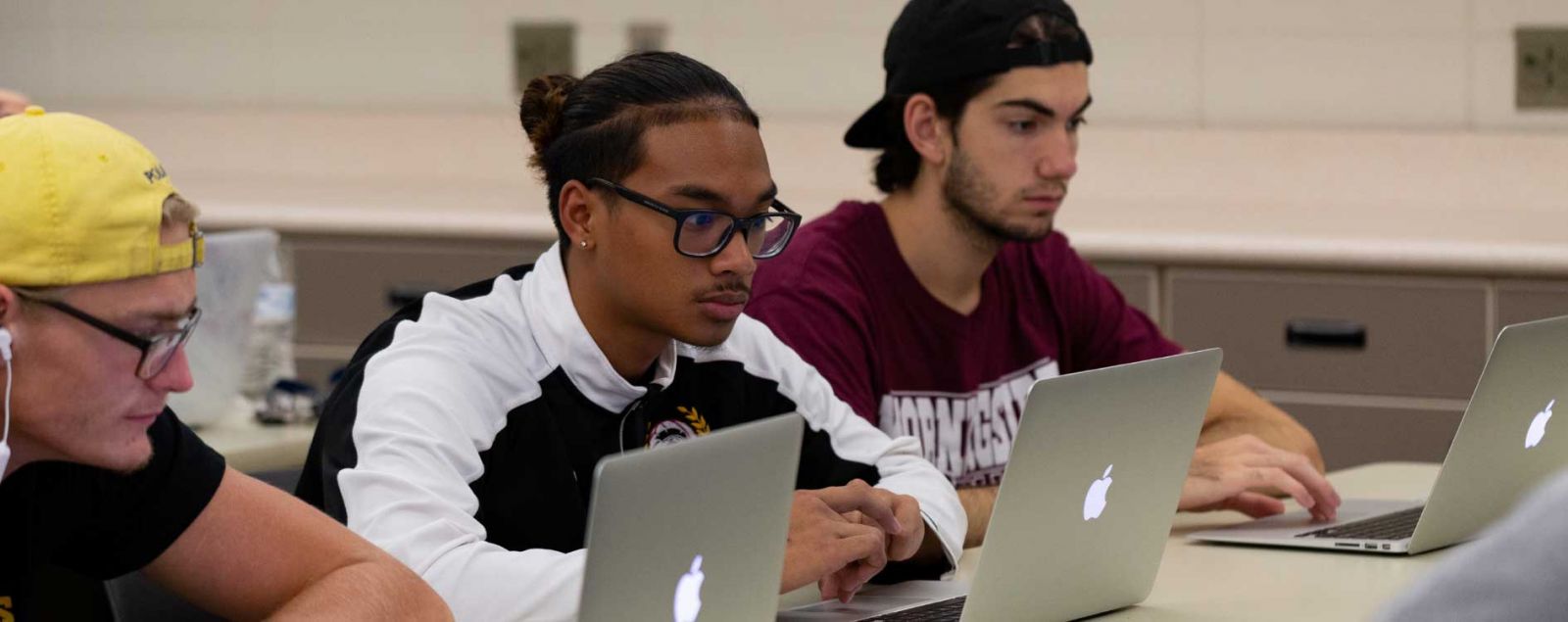 Student with Airpods on Laptop
