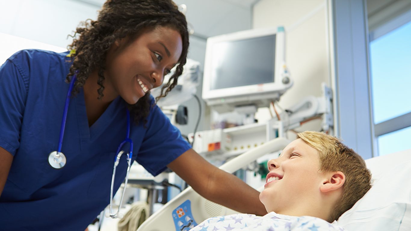 Black nurse smiling at a patient.