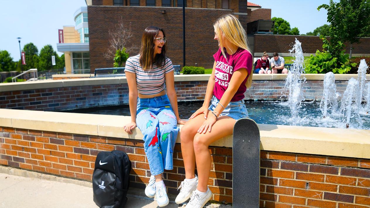 Students next to fountain with Nike backpack